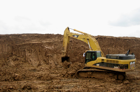 Caterpillar excavator grading earth on a Great Bear Construction dirt management site in Texas